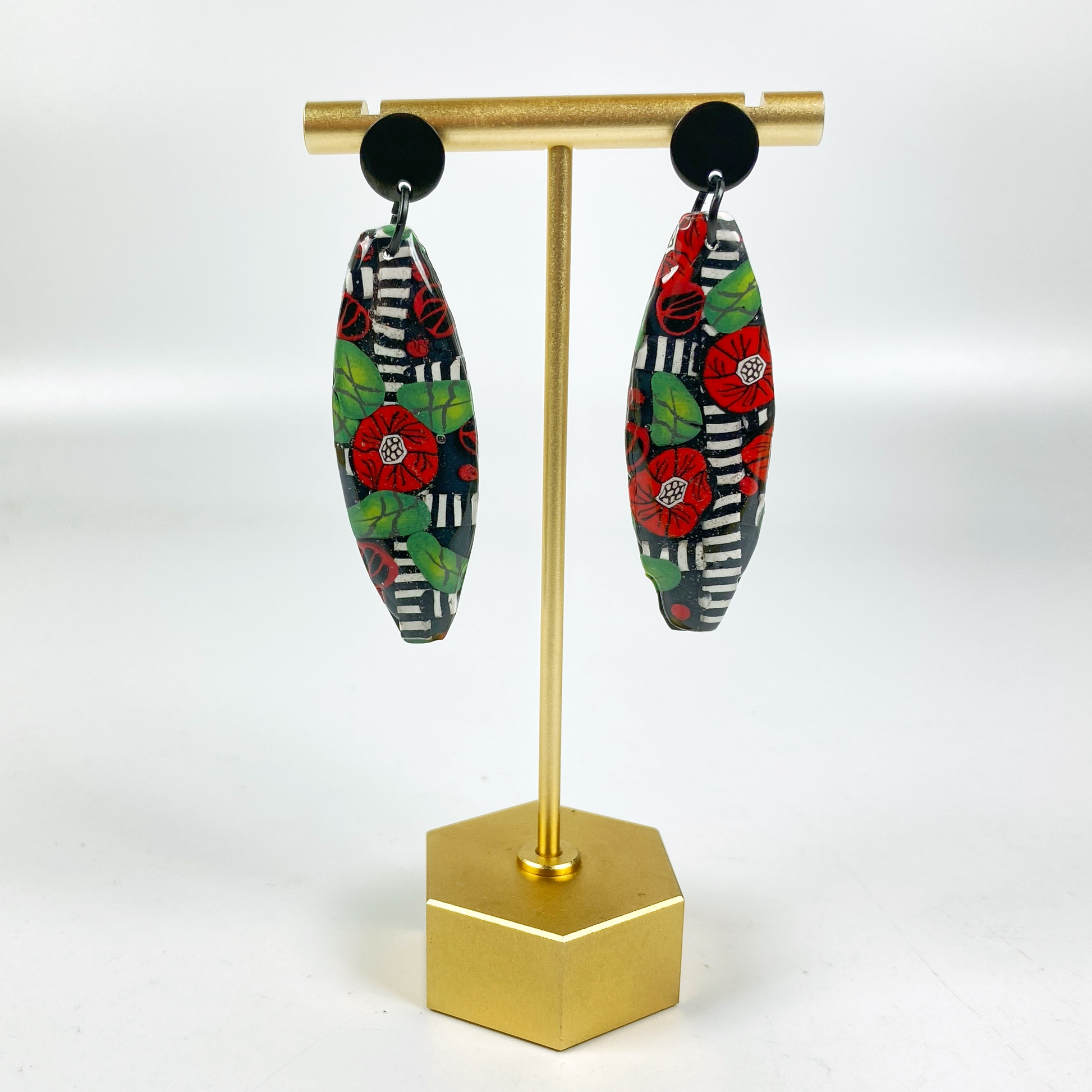 Red Lattice Rose Handmade Polymer Clay Earrings on a brass earrings stand