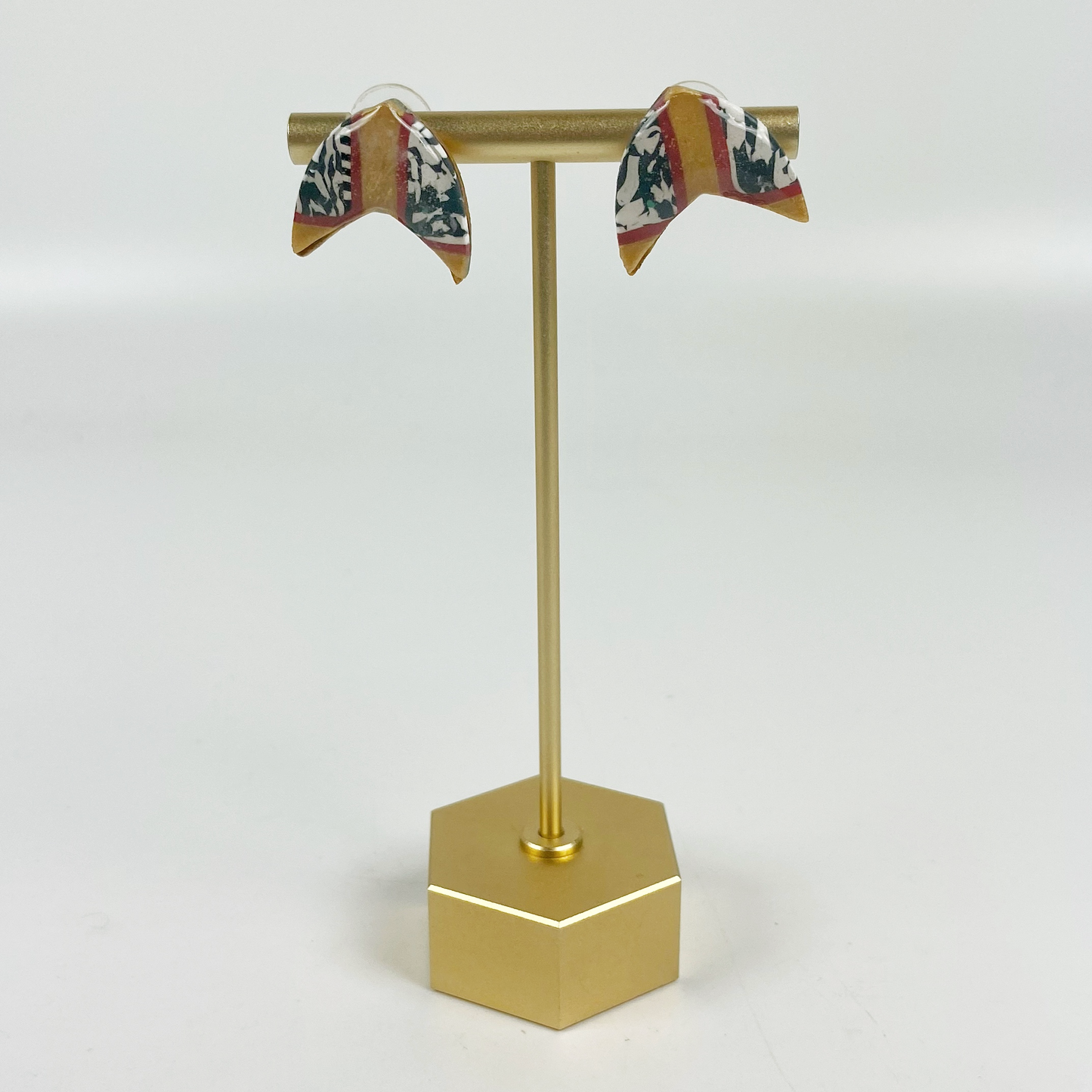 Red and Gold Handmade Polymer Clay Boomerang Stud Earrings on a brass earring stand