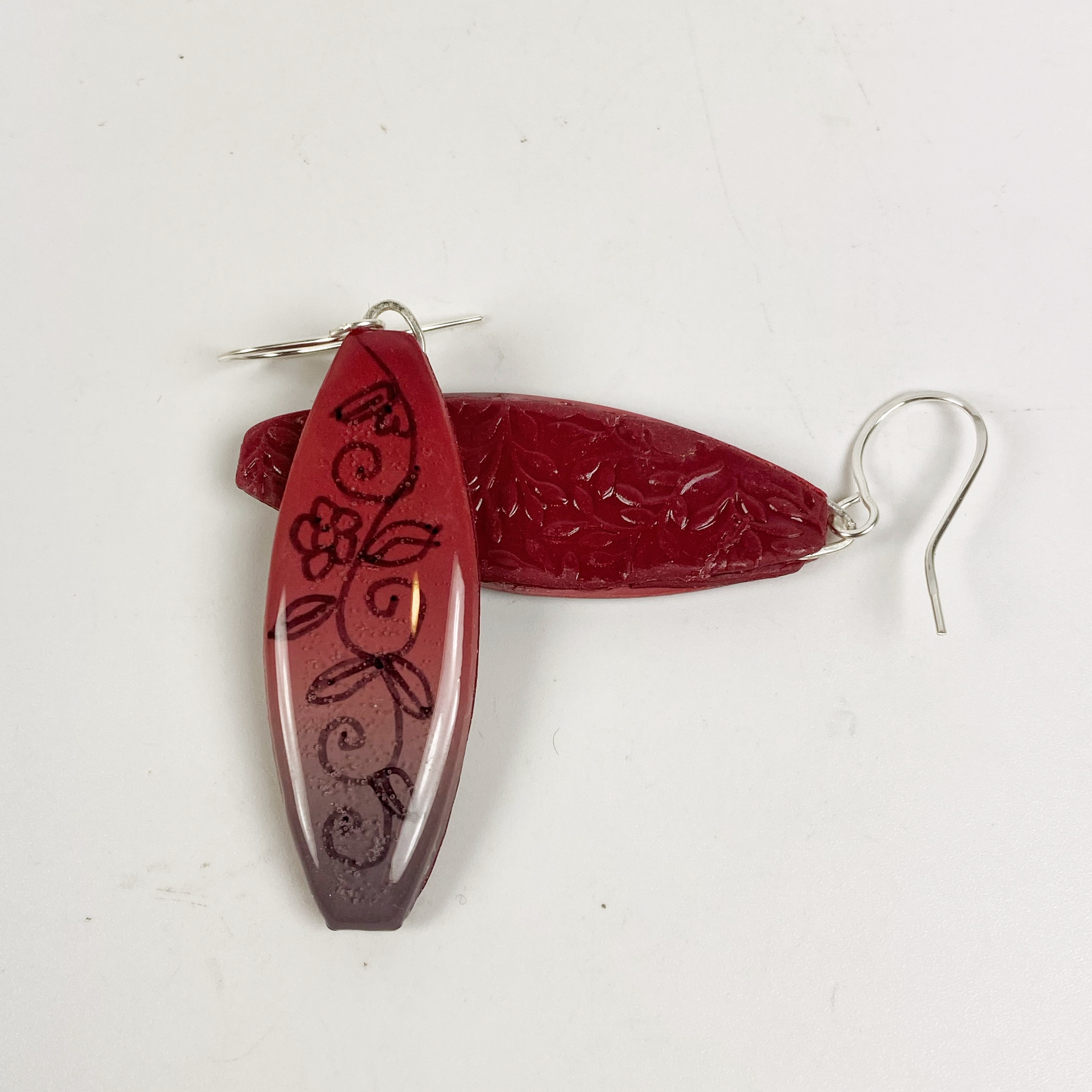 Polymer Clay Twilight Garden Handmade Dangle Earrings showing the dark red embossed back of the earrings