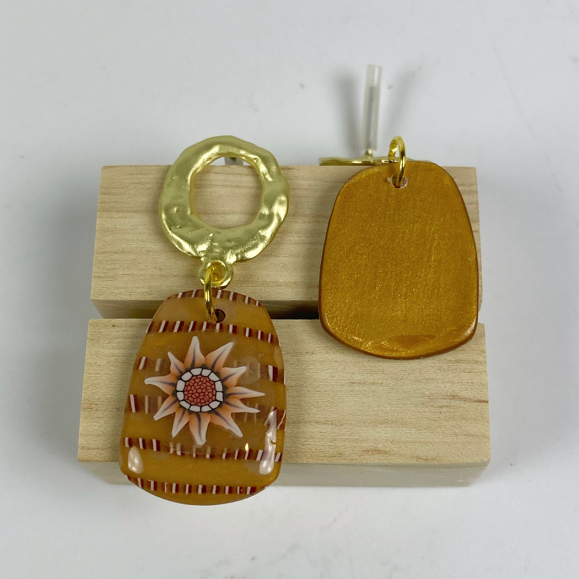 Saffron Daisy Polymer Clay Earrings  showing the front of one and the back of another.