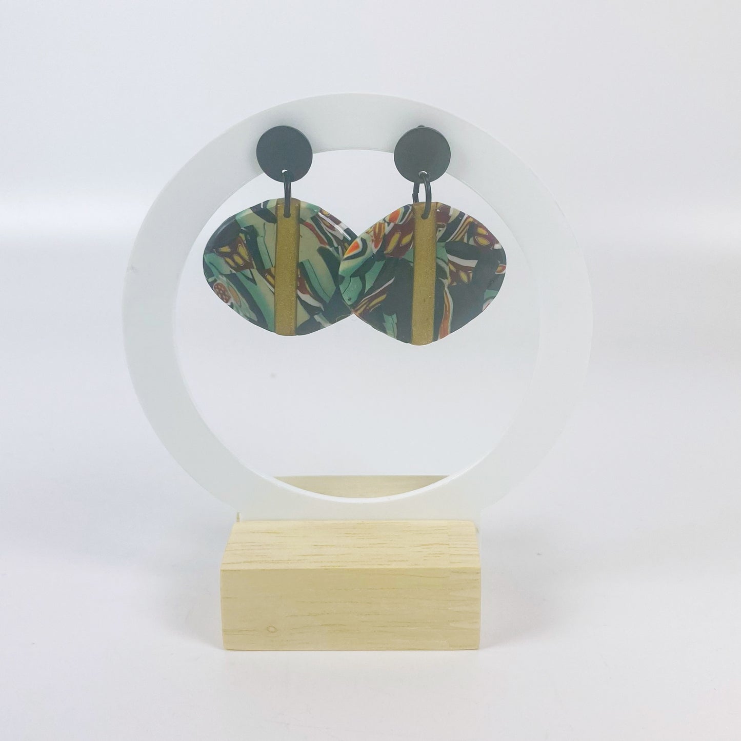 Black Green and Gold Handmade Polymer Clay Dangle Earrings on a white acrylic moon stand