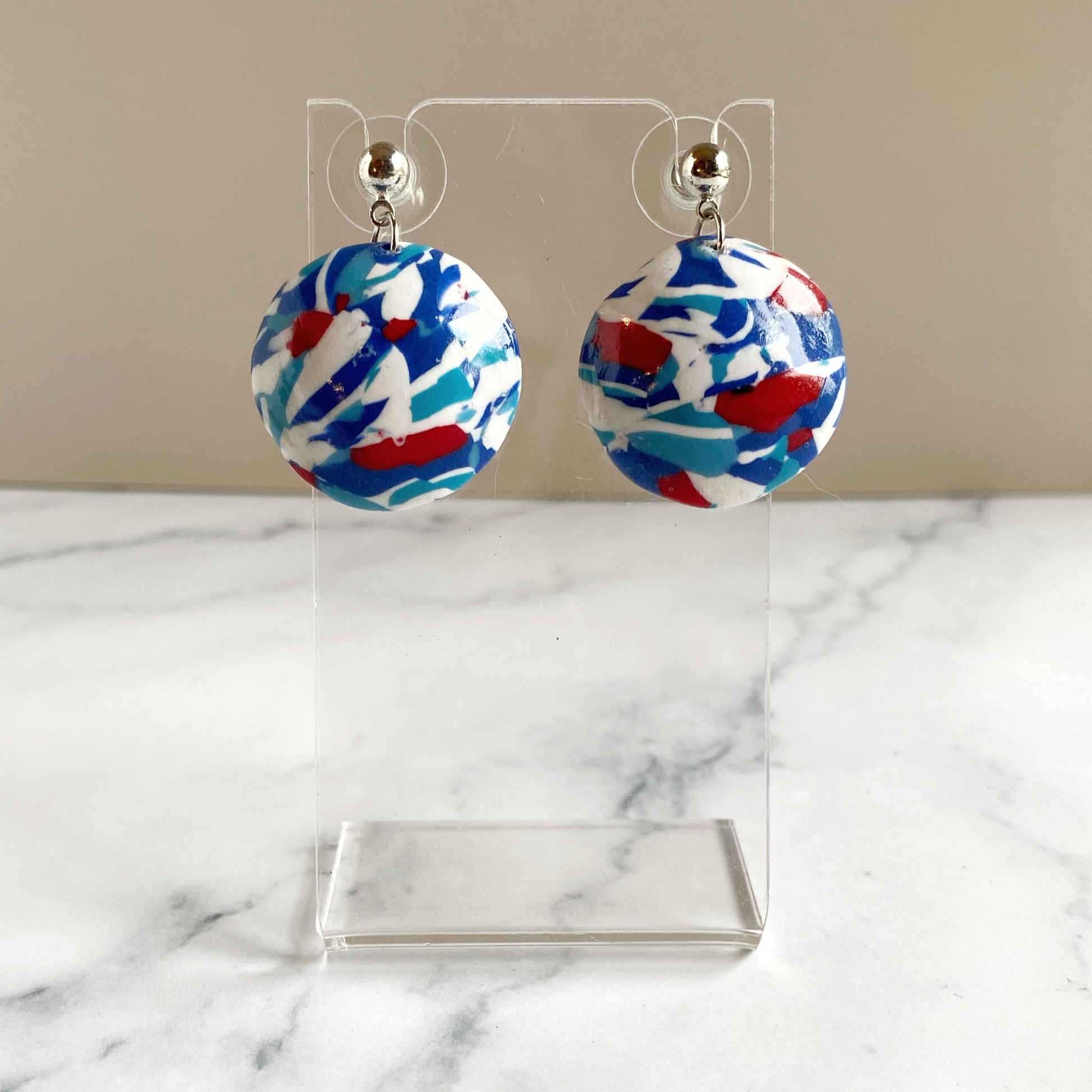 Handmade Polymer Clay Red White and Blue Earrings, on an acrylic earring stand