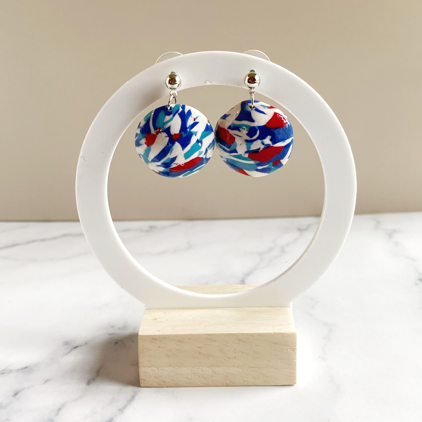 Handmade Polymer Clay Red White and Blue Earrings, on a round white earring stand