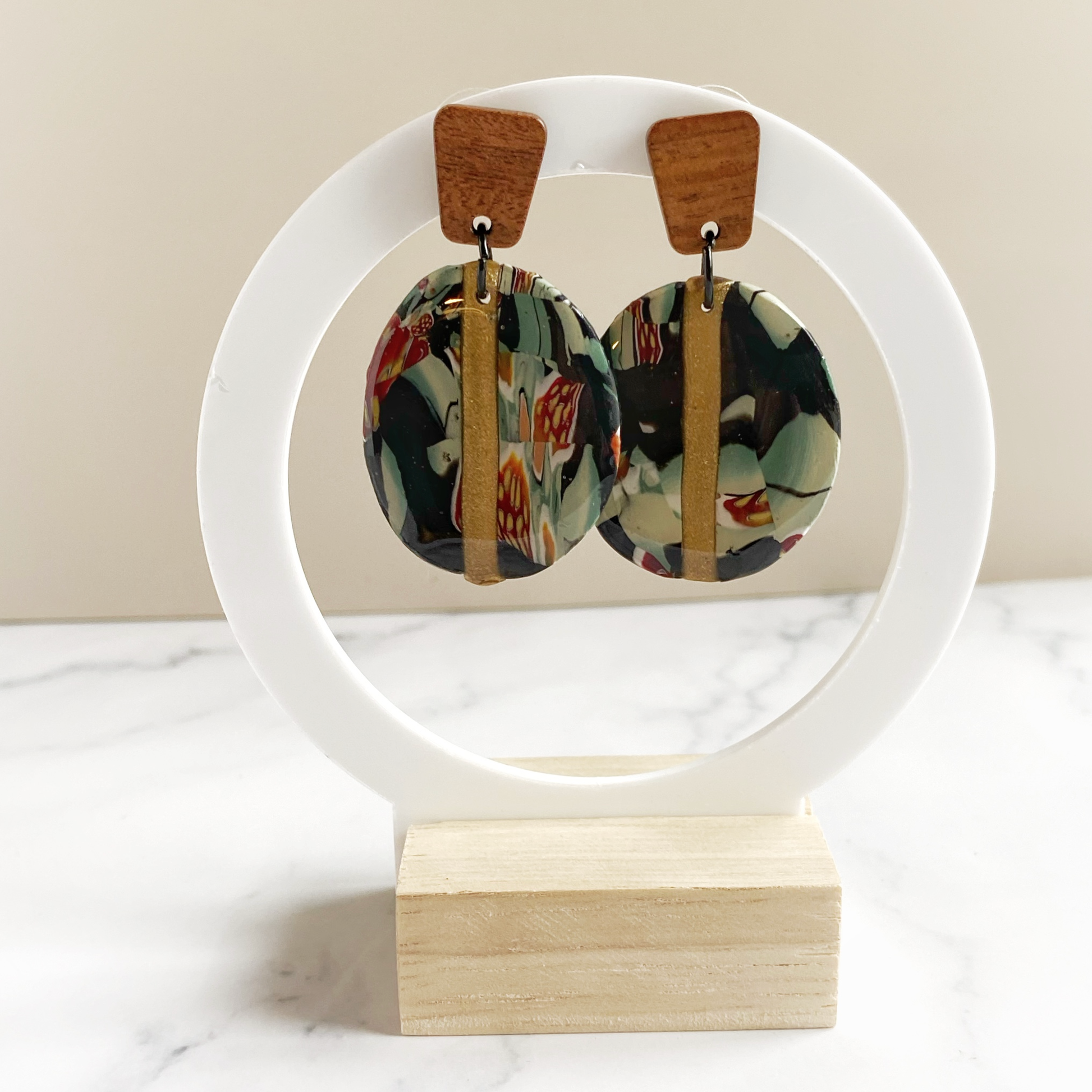 Black Gold and Green Marbled Handmade Polymer Clay Earrings on Acrylic earring stand.