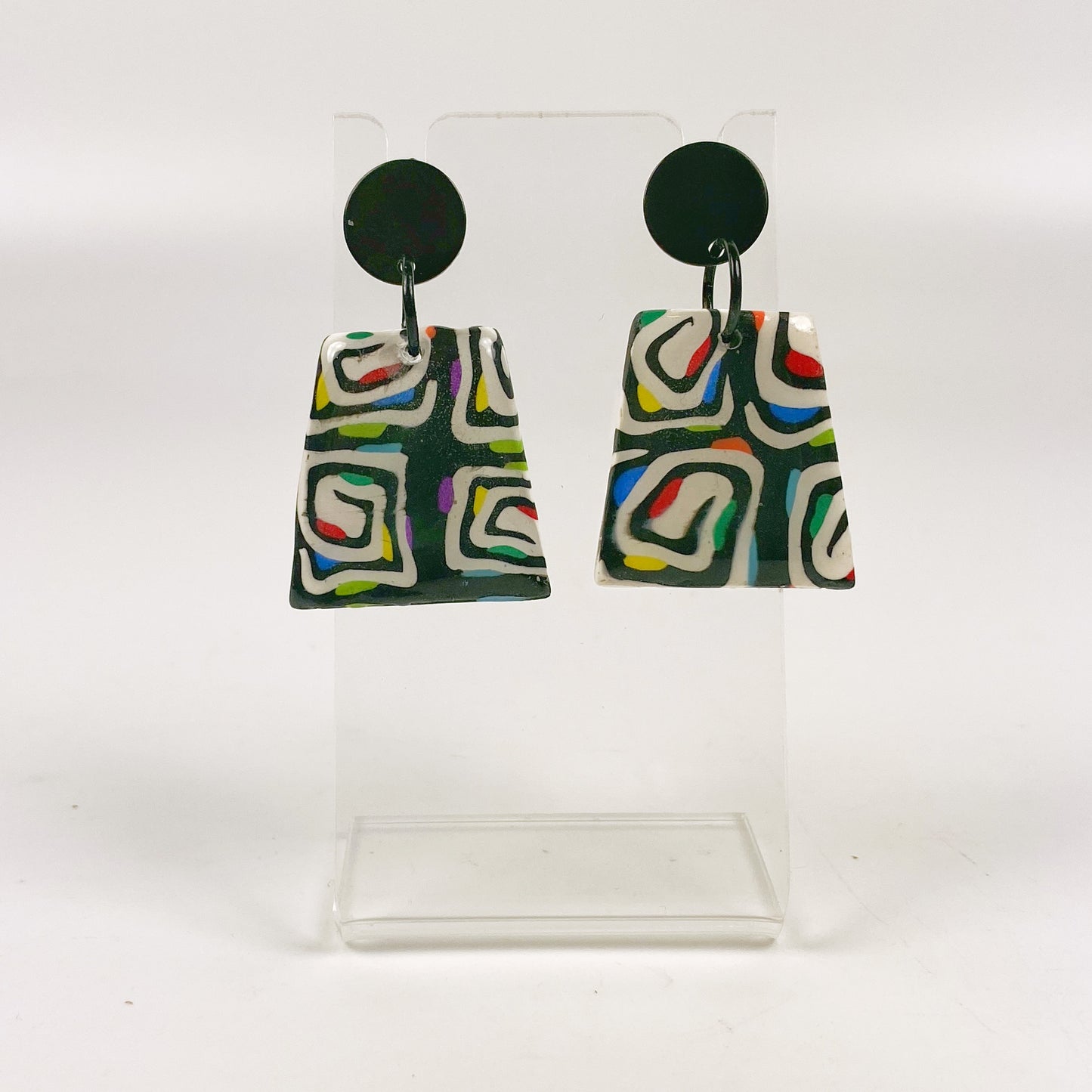 Midnight Spiral Polymer Clay Handmade Dangle Earrings on a small acrylic display stand
