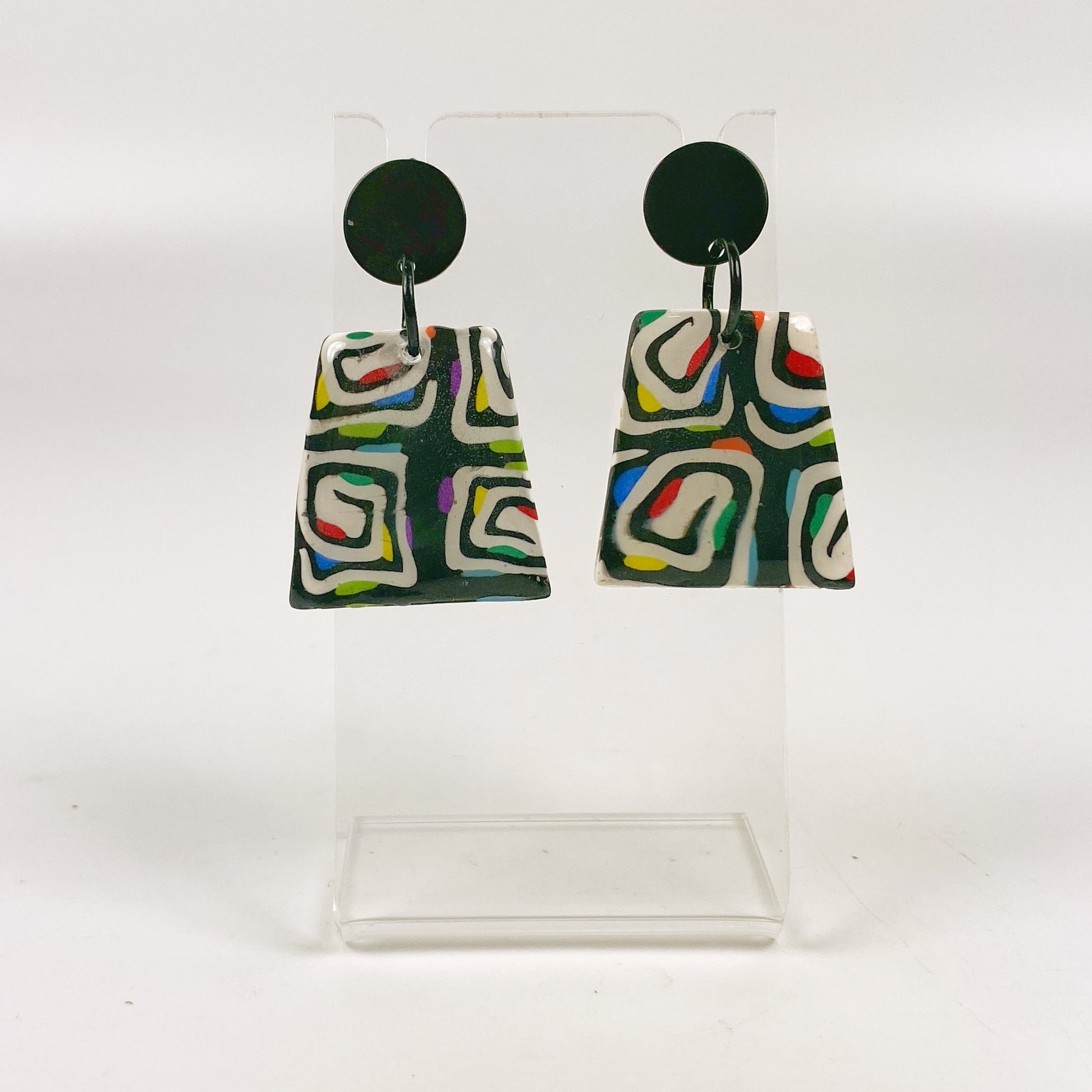 Midnight Spiral Polymer Clay Handmade Dangle Earrings on a small acrylic display stand