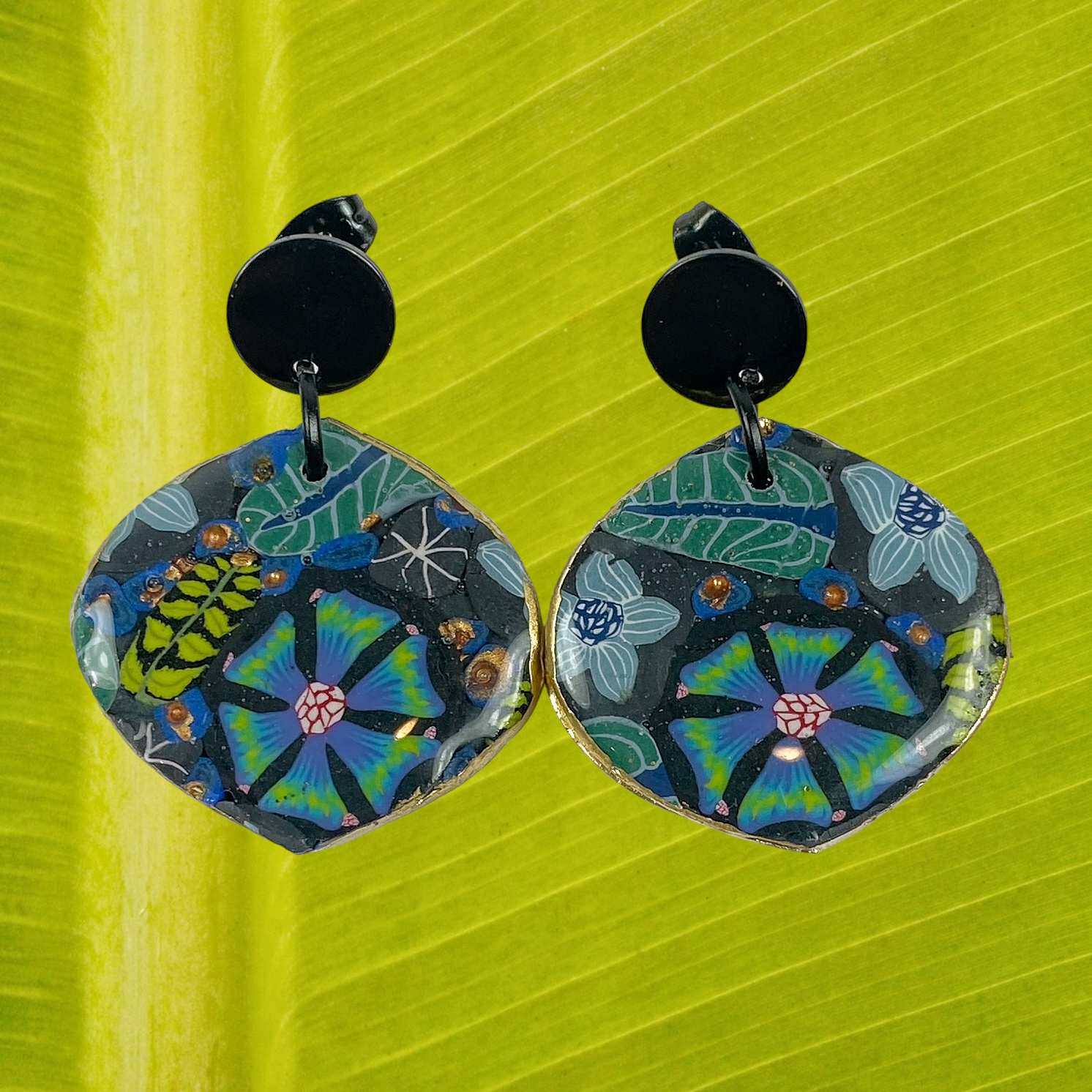 Blue Blossom Handmade Polymer Clay Dangle Earrrings on a green leaf